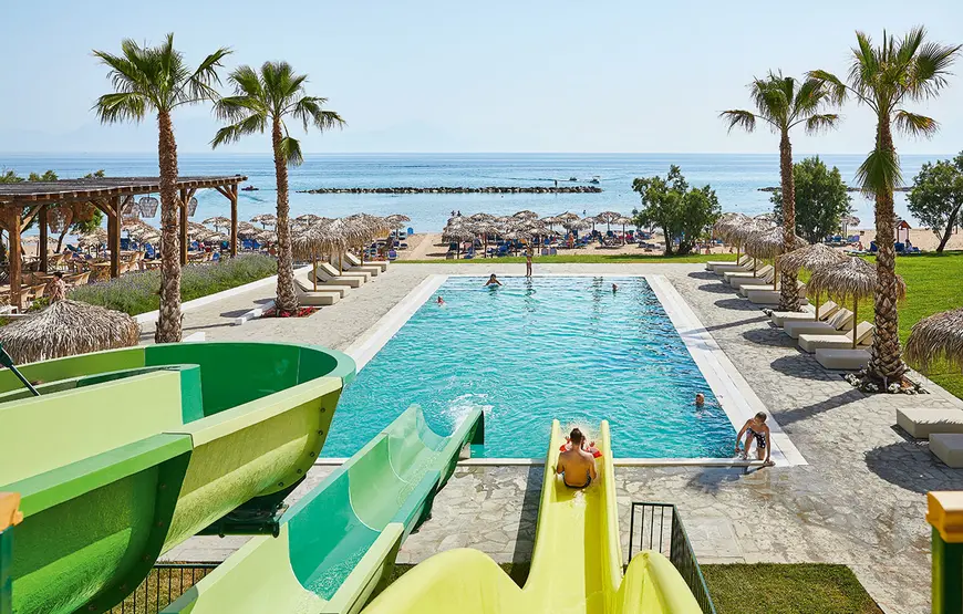 due-scivoli-si-tuffano-in-una-piscina-fronte-mare-con-qualche-palmetta-qua-e-la