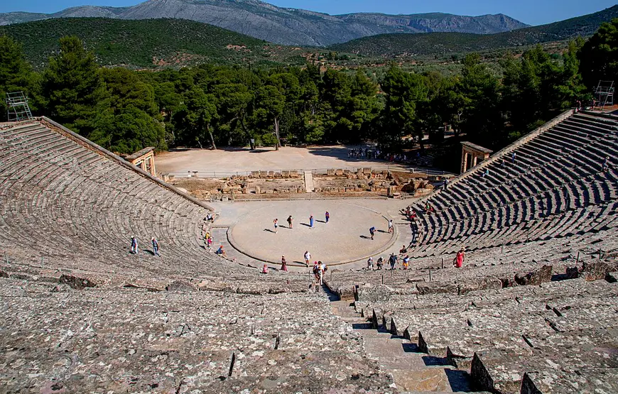 TEATRO-DI-EPIDAURO-VISTO-DALL-ULTIMA-GRADINATA-GIU-VERSO-LA-CAVEA-DIETRO-UNA-COLLINA-VERDE