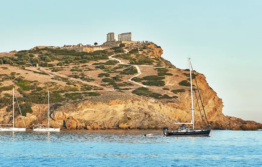 promontorio-di-capo-sounion-visto-dal-mare-con-barche-a-vela-sull-acqua