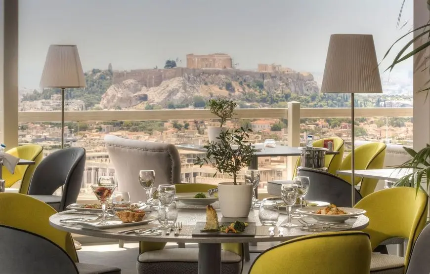tavola-apparecchiata-per-la-colazione-molto-elegante-con-poltroncine-gialle-vetrata-alle-spalle-con-vista-acropoli-di-atene
