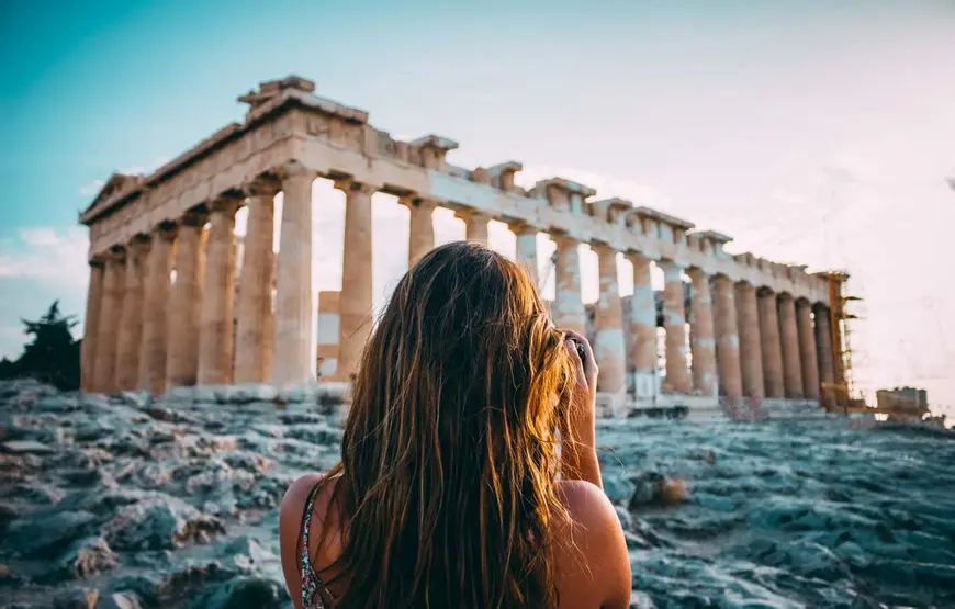 una-ragazza-di-spalle-con-una-macchina-fotografica-scatta-una-foto-al-partenone-di-atene-durante-un-mini-tour