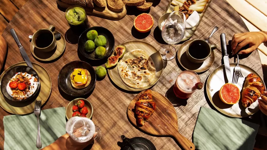 colazione-greca-in-hotel-sotto-una-pergola-apparecchiata-su-una-stuoia-con-fich-frutta-fresca-sfogliate-croissant-succhi