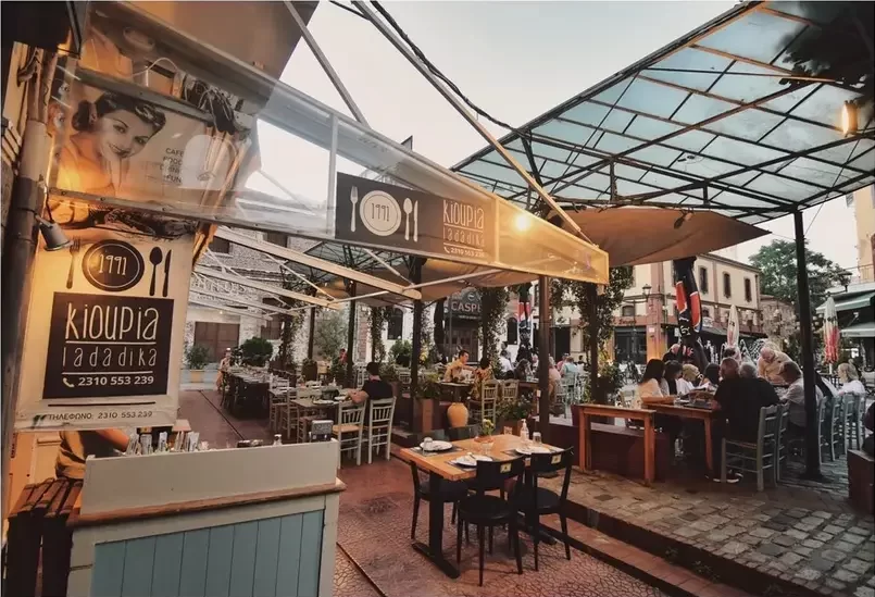 interno-di-un-locale-a-salonicco-con-grande-spazio-sotto-una-vela-di-vetro-tavolini-di-legno-si-chiama-kioupia-e-si-trova-a-salonicco