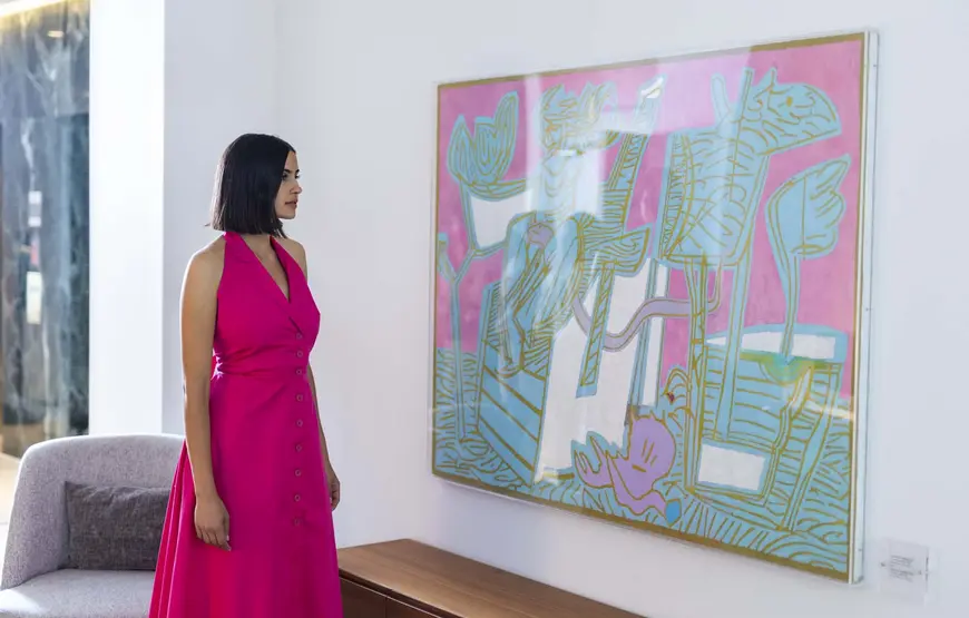 una-ragazza-vestita-color-ciclamino-guarda-ammirata-un-quadro-che-ha-come-sfondo-il-color-ciclamino-e-un-disegno-astratto