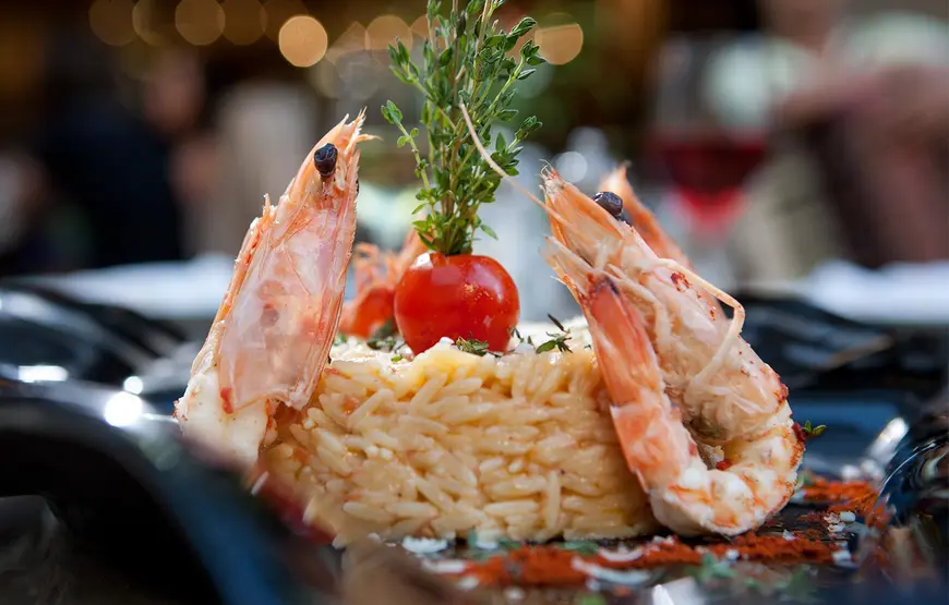 due-gamberetti-cotti-se-ne-stanno-ai-lati-di-una-quiche-di-riso-con-un-pomodorino-in-cima-piatto-invitante-di-salonicco