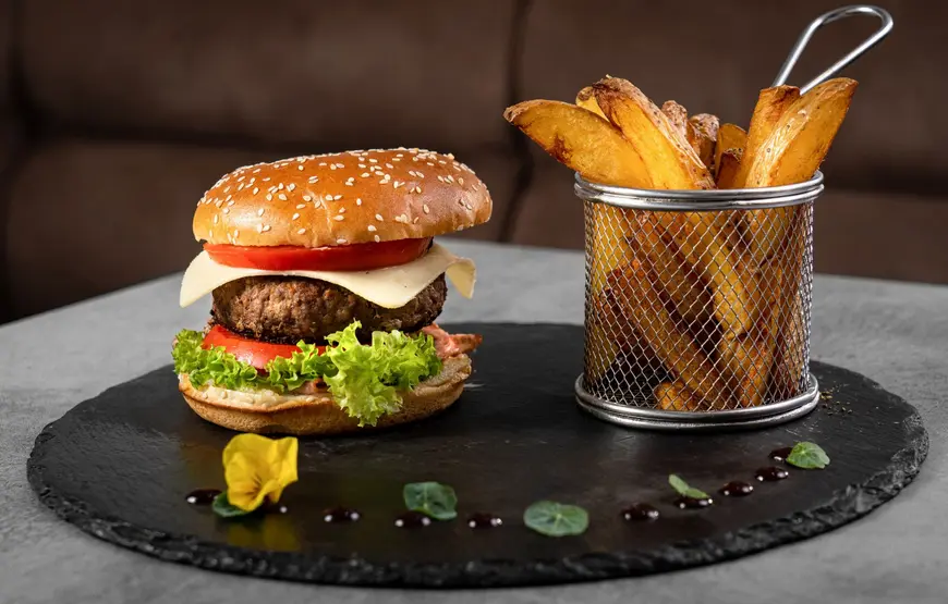 piatto-nero-lavico-con-sopra-un-panino-gourmet-e-di-fianco-un-cestello-con-patate-fritte
