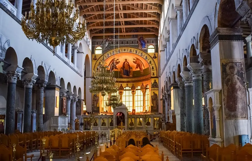 interno-della-chiesa-di-san-demetrio-a-salonicco-con-navata-centrale-che-culmina-nella-nicchia-centrale-con-lunetta-istoriata-in-alto-le-pareti-laterali-sono-bianche-con-colonnato