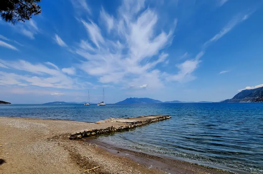 spiaggia-con-piccola-striscia-in-mezzo-al-mare-due-caicco-fermi-e-un-cielo-azzurro-che-si-confonde-con-l'orizzonte