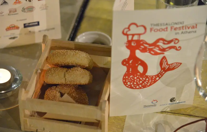 pane-tipico-di-salonicco-esposto-durante-il-thessaloniki-food-festival-come-riportato-nella-bustina-di-carta-di-fianco-al-pane-con-l-immagine-di-una-sirena-col-cappello-da-chef
