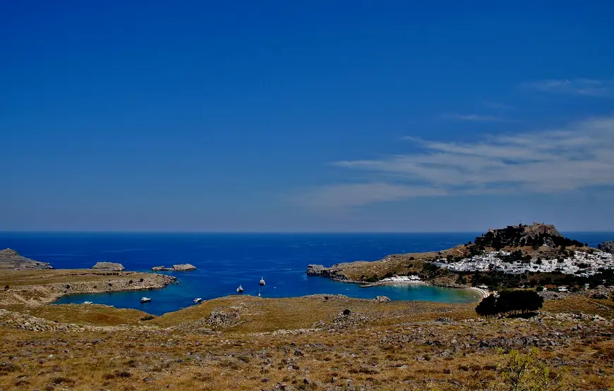 vista-panoramica-di-lindos-a-rodi-con-la-baia-san-paolo-in-fondo-auna-valle-rada-e-di-fianco-le-case-cubiche-in-cima-l-acropoli