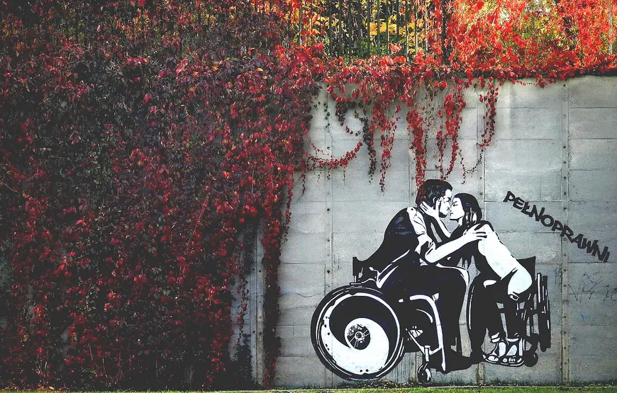 murales-di-una-ragazza-e-un-ragazzo-seduti-in-carrozzina-che-si-baciano-sotto-una-cascata-di-edere-rosse