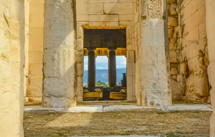 propilei-acropoli-atene ingresso-greco-chiamato-propilei-si-vedono-due-colonne-grandi-e-dietro-altre-colonne-con-affaccio-verso-una-montagna
