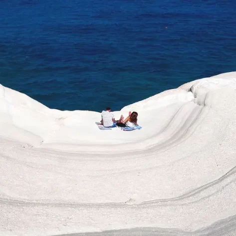 sarakiniko-una-spiaggia-di-marmo-bianco-a-onde-dove-sono-una-coppia-a-prendere-il-sole-sotto-ancora-mare-turchese