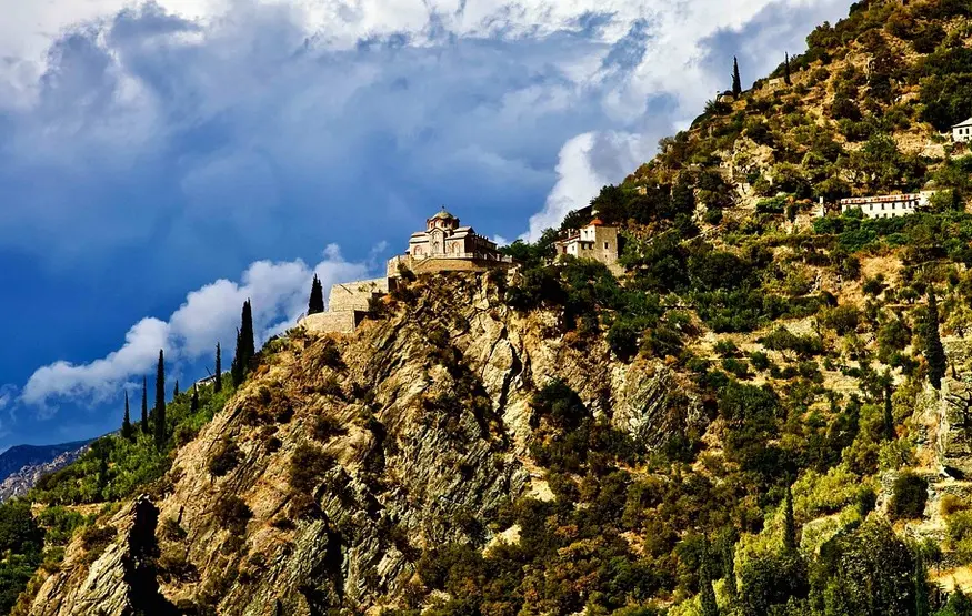 un-monastero-del-monte-athos-in-cima-a-un-costone-roccioso-perpendicolare-al-cielo-azzurro