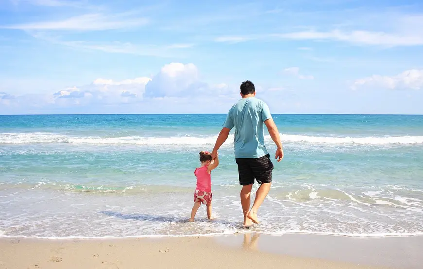 un-papa-con-una-bimba-camminano-lungomare-in-grecia