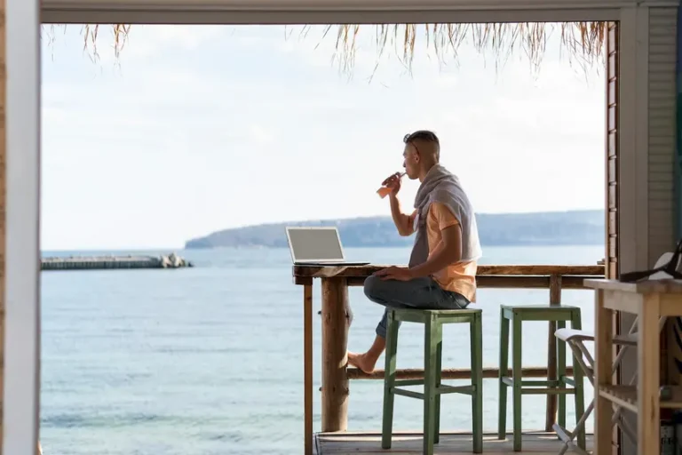un-uomo-siede-su-uno-sgabello-in-un-lounge-bar-davanti-al-mare