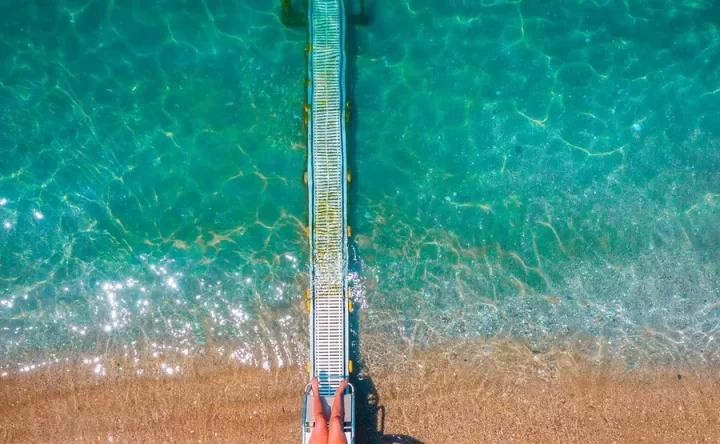 SEATRAC-GRECIA-SENZA-BARRIERE-GRECIA-PER-TUTTI1 UNA-PASSERELLA-SCENDE-DALLA-SPIAGGIA-FIN-DENTRO-L-ACQUA-SI-TRATTA-DEL-SEATRAC-CHE-CON-UN-TELECOMANDO-AIUTA-CHI-HA-PROBLEMI-MOTORI-A-ENTRARE-IN-ACQUA-IN-AUTONOMIA