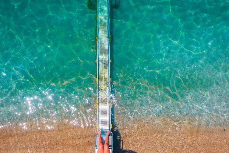 UNA-PASSERELLA-SCENDE-DALLA-SPIAGGIA-FIN-DENTRO-L-ACQUA-SI-TRATTA-DEL-SEATRAC-CHE-CON-UN-TELECOMANDO-AIUTA-CHI-HA-PROBLEMI-MOTORI-A-ENTRARE-IN-ACQUA-IN-AUTONOMIA