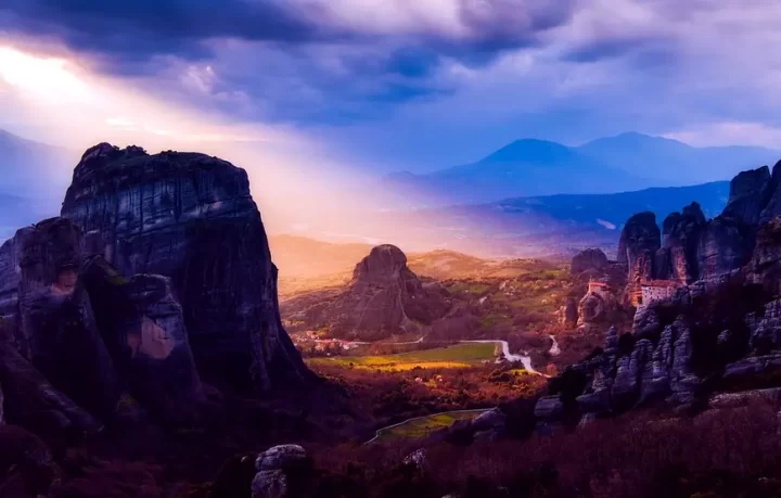 paesaggio-surreale-di-meteora-sito-greco-eccellenza-al-tramonto-con-sole-caldo-che taglia-la-valle