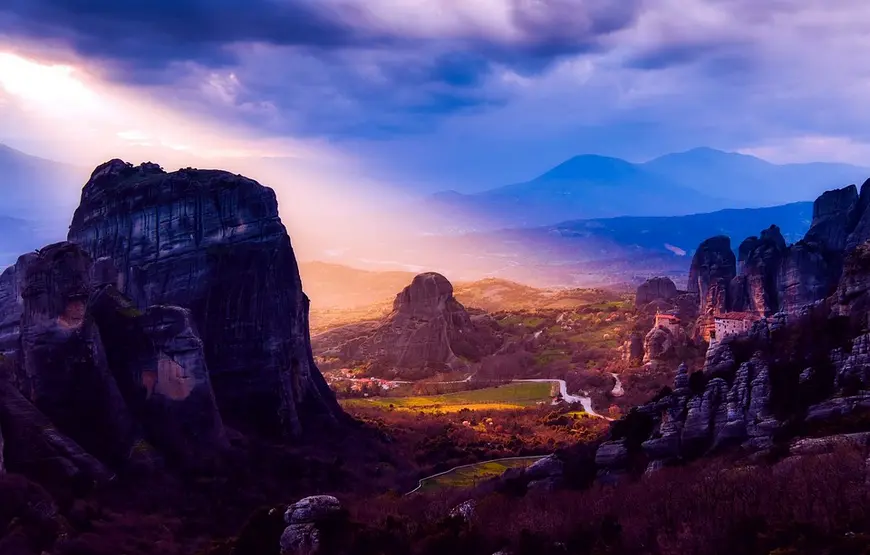 paesaggio-surreale-di-meteora-sito-greco-eccellenza-al-tramonto-con-sole-caldo-che taglia-la-valle