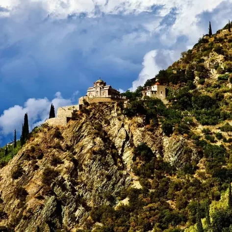 un-monastero-del-monte-athos-in-cima-a-un-costone-roccioso-perpendicolare-al-cielo-azzurro