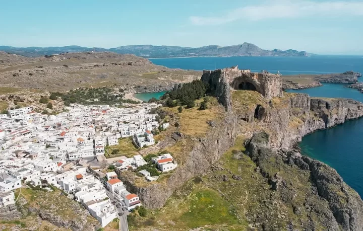 RODI-CITTA-CON-IL-MONTE-SMITH-E-L-ACROPOLI-E-IL-TEMPIO-DI-APOLLO-foto-di-ww.mitsishotels.com rodi-citta-vista-dall-alto-con-lo-sperone-roccioso-che-innalza-l-acropoli-al-cielo-e-sotto-le-casette-bianche-della-citta-vecchia-di-rodi